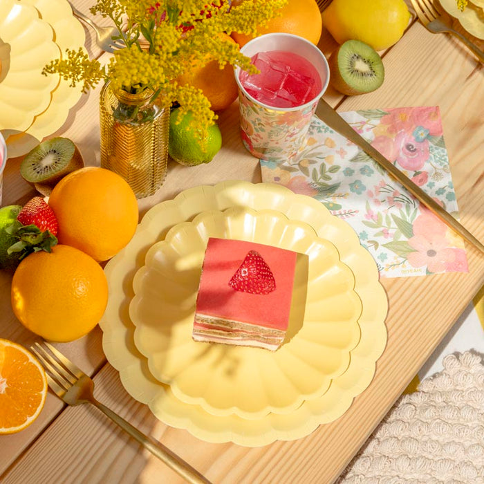 Masă de petrecere cu farfurii floare galben pastel și veselă florală