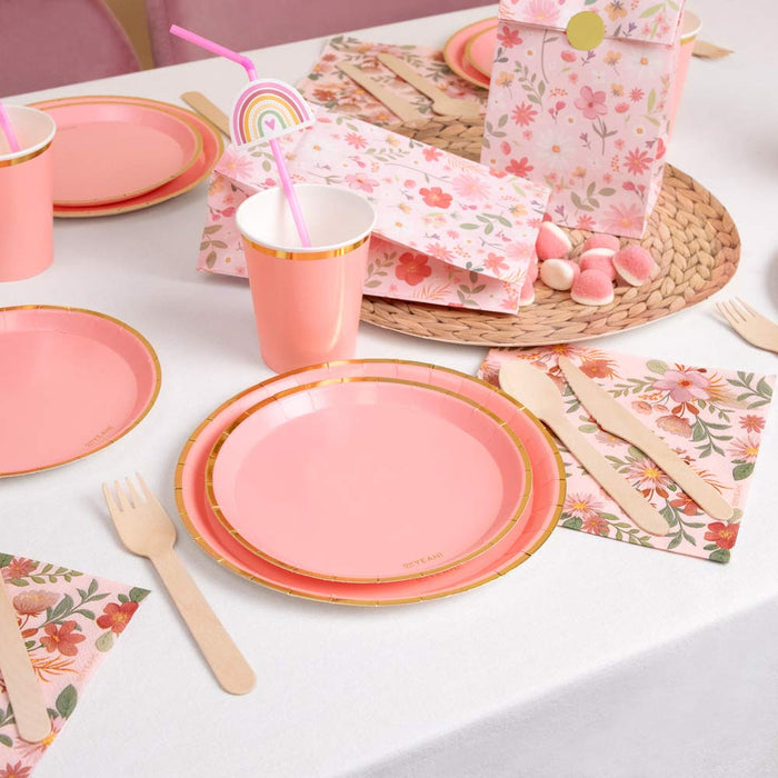 Masă de petrecere cu pahare roz pastel cu margine aurie și veselă florală